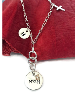 Sterling-silver-chain-mom-charm-necklace-on-red-leather-background