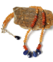 orange  & blue gemstone collar necklace on rock