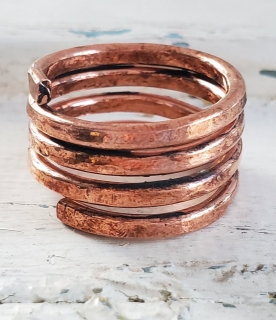 hand forged copper coil ring on white distressed wood