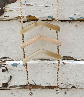 neutral colored Chevron necklace on white wood