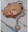 Colorful gemstone long Italian coin necklace on rock