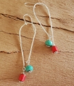 silver elongated loop earrings with red and teal gemstones on wood