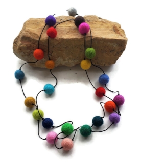 multi color felted pom pom necklace on rock