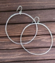 hammered 2" silver hoop earrings on wood