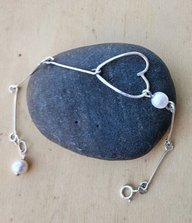 silver bar, open heart white pearl bracelet on black rock