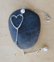 silver bar, open heart white pearl bracelet on black rock CLose Up