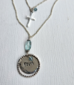 close up of hammered edge silver faith charm necklace on white