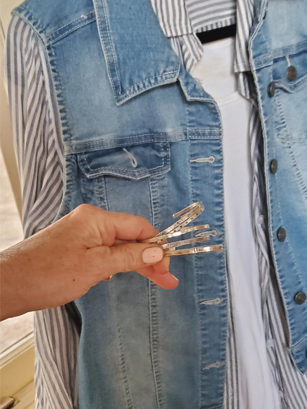holding a stack of sterling cuffs