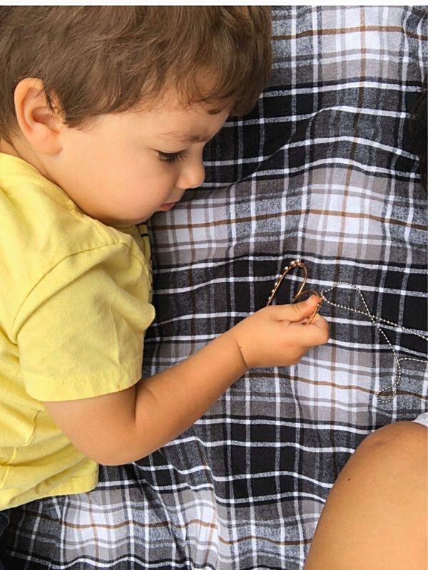 child touching moms heart necklace