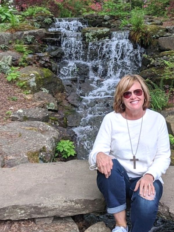 sitting in the garden with a cross necklace