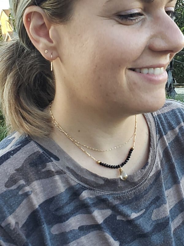 wearing a gold chain black crystal necklace