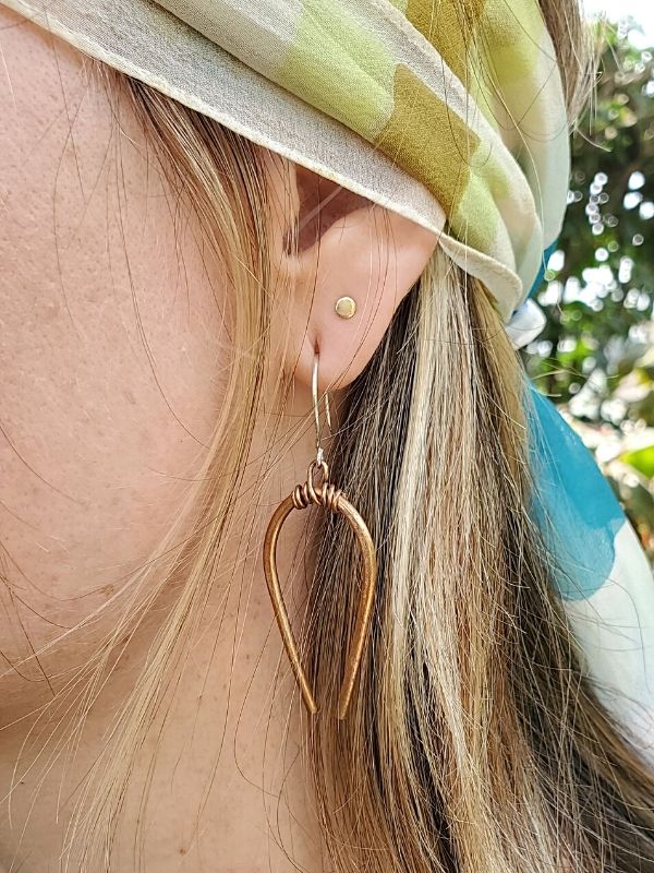 wearing artisan horsehoe earrings & a headscarf