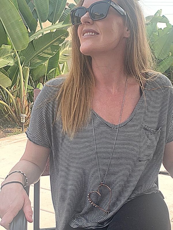 wearing striped tee with long heart necklace
