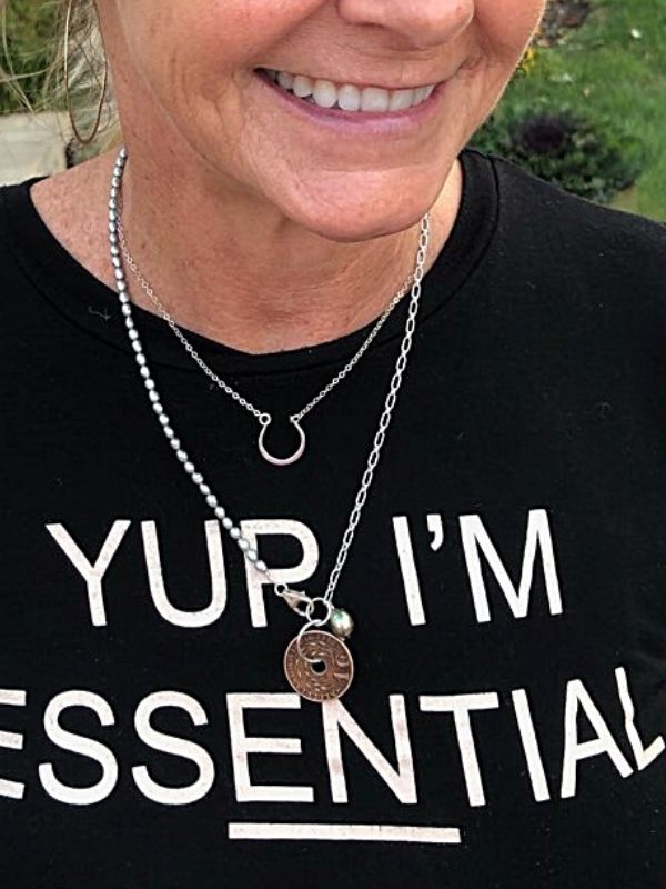 female with black tee shirt and old coin necklace