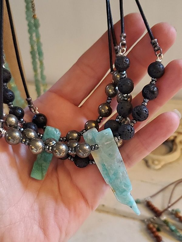 essential leather gemstone necklaces in hand