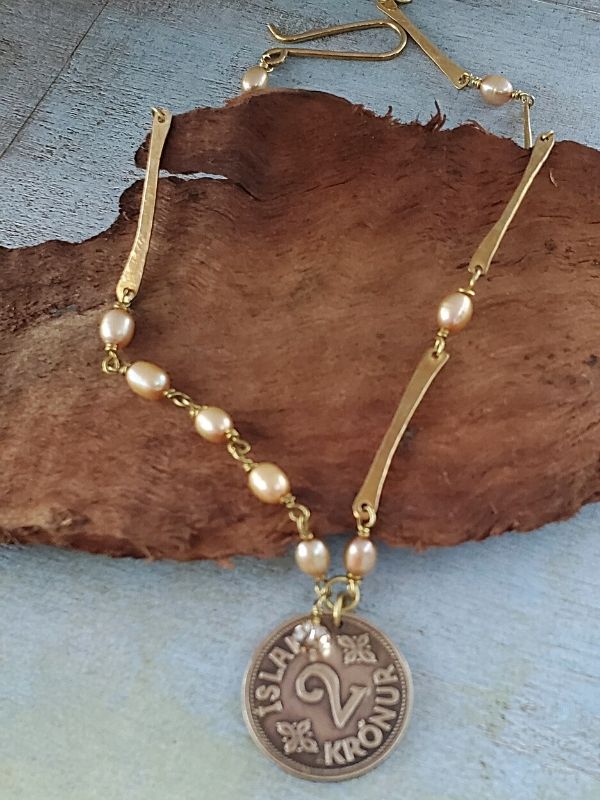 pearl Iceland coin necklace on green background