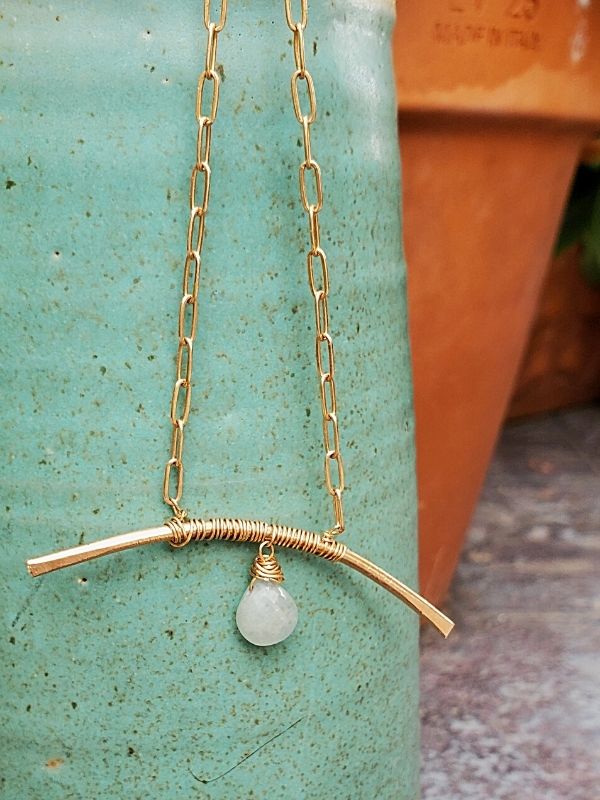 blue aquamarine gemstone arc necklace on ceramic piece