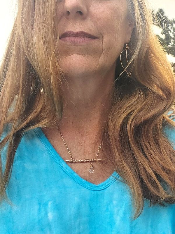 wearing bronze bar necklace leaf earrings