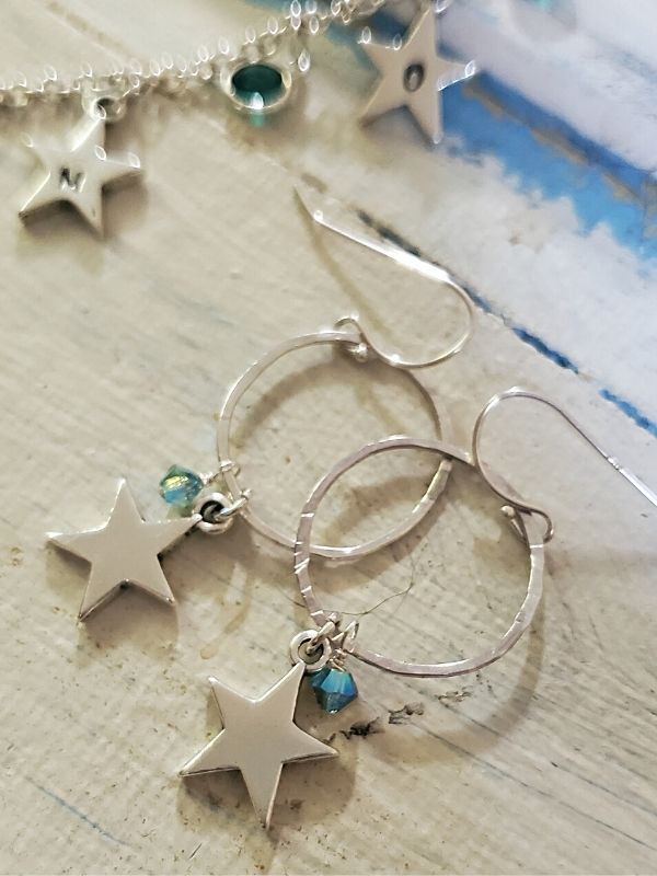 silver hoop star crystal earrings on white trunk
