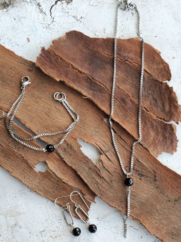 modern silver & black jewelry set on wood