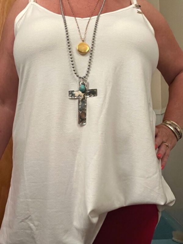 wearing a silver cross necklace & gold locket