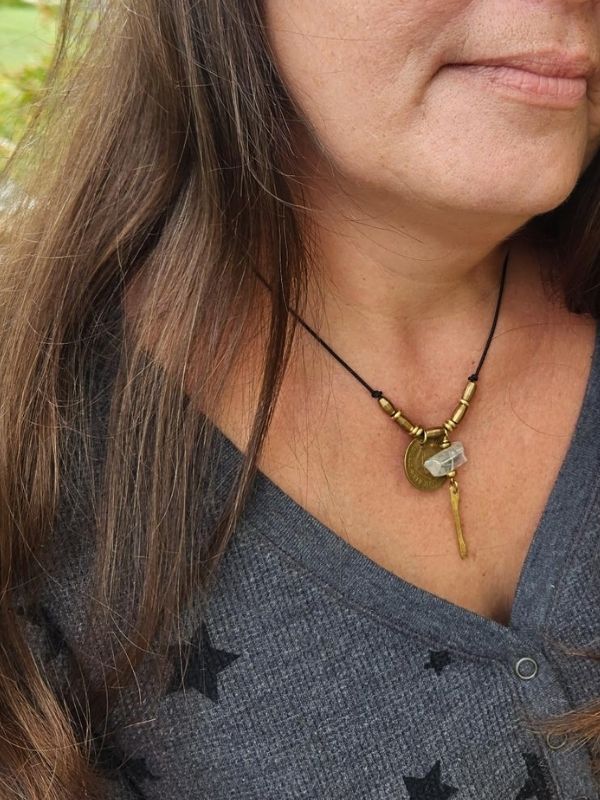 gold token clear gemstone necklace on female