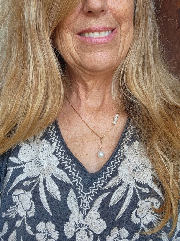 model wearing pearl necklace & embroidered top