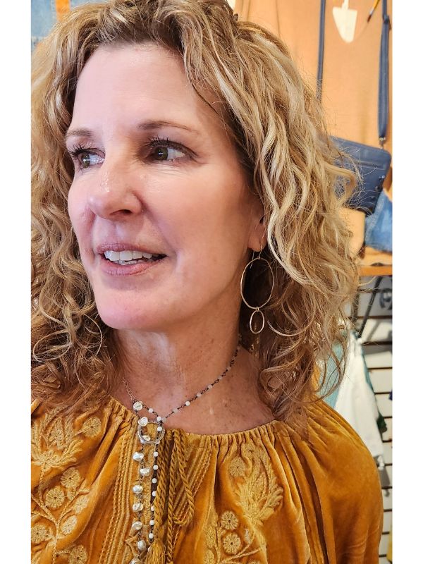 gold earrings on woman with blonde wavy hair