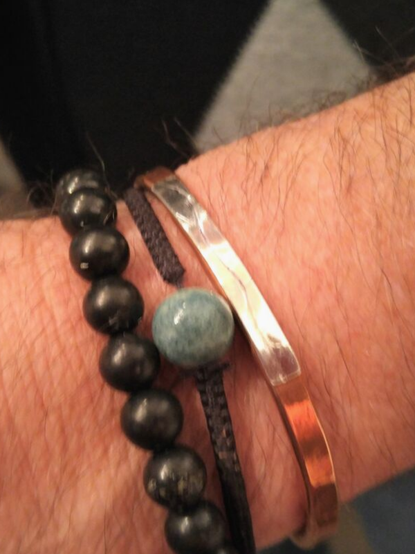 closeup mans wrist with bracelets