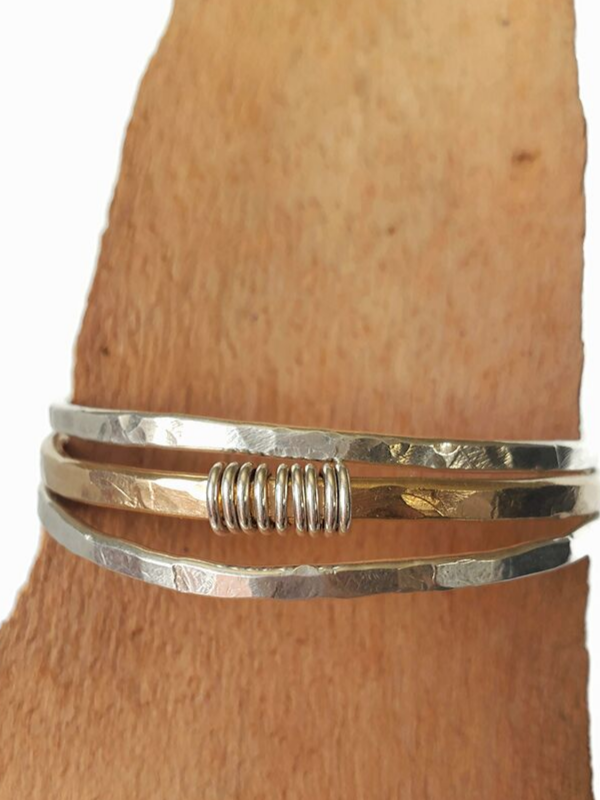 silver and gold cuffs on wood