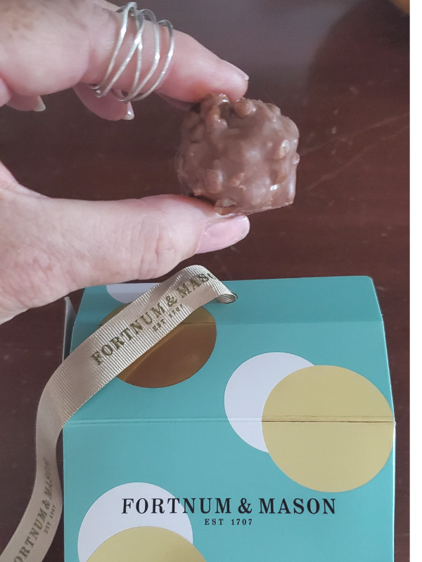 finger with silver ring holding a truffle