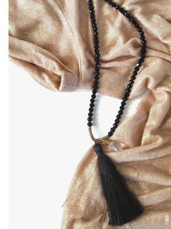 pale gold top with long black necklace